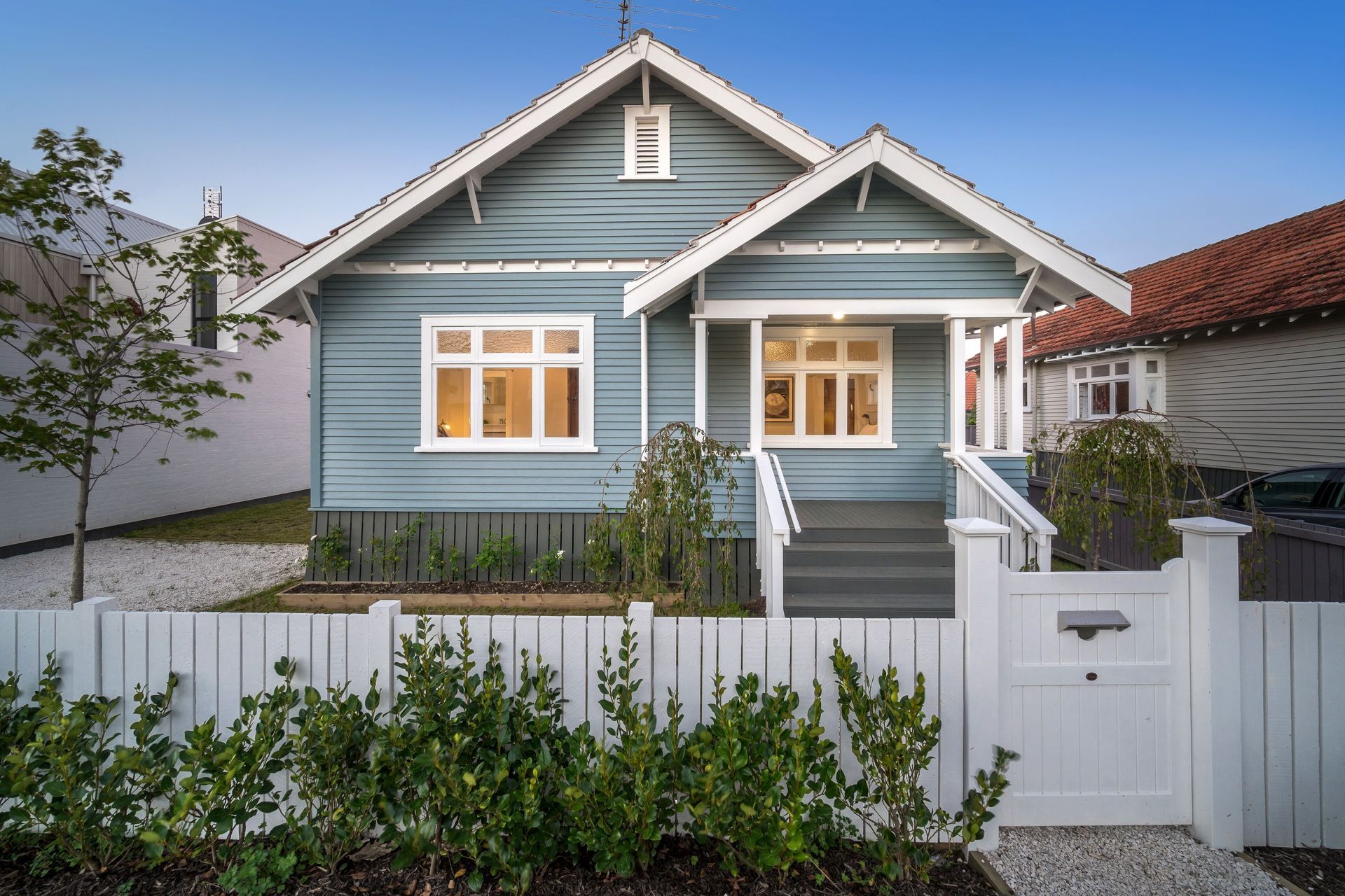 A weatherboard villa in Auckland, lit warm at dusk